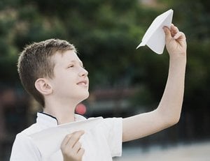 boy throwing paper airplane